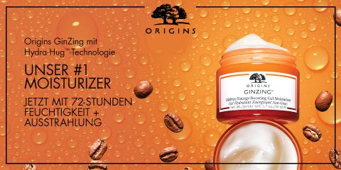 Ein Bild der Feuchtigkeitscreme Origins GinZing mit Hydra-Hug-Technologie. Der Text hebt sie als die Feuchtigkeitscreme Nummer eins hervor, die 72 Stunden Feuchtigkeit spendet und strahlend wirkt. Der Hintergrund zeigt Kaffeebohnen und -tröpfchen, die die energetisierenden Eigenschaften betonen.