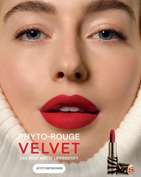 Nahaufnahme einer Person mit leuchtend rotem Lippenstift. Der Fokus liegt auf glatter Haut und minimalem Make-up. Der Text lautet „Phyto-Rouge Velvet – Der neue matte Lippenstift“ und „Jetzt entdecken“ neben einem Lippenstiftbild.