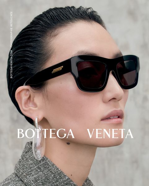Person mit zurückgekämmten Haaren, großer schwarzer Sonnenbrille und übergroßen, transparenten Creolen. Der Text lautet „Bottega Veneta“. Die Person blickt leicht zur Seite vor einem neutralen Hintergrund.