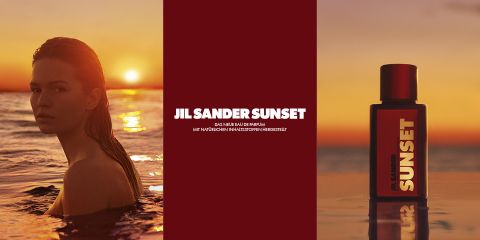 Links steht eine Frau bei Sonnenuntergang im Meer, rechts ist eine Flasche Parfüm Jil Sander Sunset zu sehen. Auf dem roten Mittelfeld steht der Text: „JIL SANDER SUNSET.