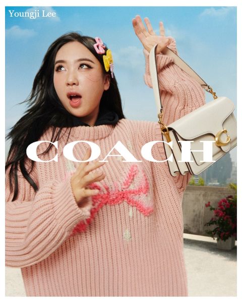 Eine Person hält eine weiße Handtasche und trägt einen rosa Strickpullover und Haarschmuck. Im Hintergrund sind ein blauer Himmel und eine Dachlandschaft zu sehen. Der Text auf dem Bild lautet „Youngji Lee“ und „Coach“.