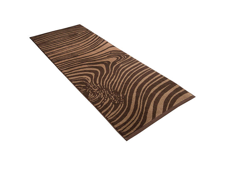 Ein rechteckiger braun-schwarz gestreifter Teppich mit einem Muster, das an Holzmaserung erinnert, liegt flach auf einem weißen Hintergrund.