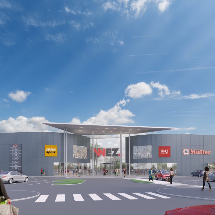 Ein modernes Einkaufszentrum mit mehreren Markenlogos über den Ladenfronten, darunter Spar, Giga Sport und Müller. Der Eingang verfügt über ein großes Vordach und in den umliegenden Straßen parken Autos und Fußgänger. Strahlend blauer Himmel mit einigen Wolken.