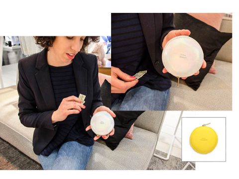 Eine Person in einem dunklen Blazer und Jeans hält einen runden schillernden Beutel und legt eine gefaltete Banknote hinein. Das Bild zeigt außerdem eine Nahaufnahme des Beutels und eine gelbe Version des Beutels auf weißem Hintergrund.