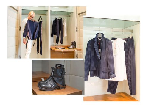 Eine Person hält einen dunklen Blazer vor einen Spiegel. In einem offenen Kleiderschrank daneben sind weitere Blazer, Hemden und ein schwarzer Stiefel auf einem Regal zu sehen. In einer anderen Ansicht sind ein Nadelstreifenanzug, ein weißes Kleid und der gleiche schwarze Stiefel zu sehen.