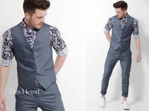 Ein Mann in einer maßgeschneiderten, grau karierten Weste und Hose, dazu ein schwarz-weißes Hemd mit Blumenmuster und hochgekrempelten Ärmeln. Er trägt weiße Turnschuhe. Das Bild zeigt zwei Ansichten: eine Nahaufnahme seines Oberkörpers und eine Ganzkörperansicht von der Seite. Der Text lautet „Das Hemd.