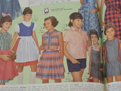 Eine alte Katalogseite mit sechs jungen Mädchen, die vor einem grünen Hintergrund verschiedene farbenfrohe Kleider und Outfits im Stil der 1960er Jahre vorführen, darunter Streifen, Karos und Muster.