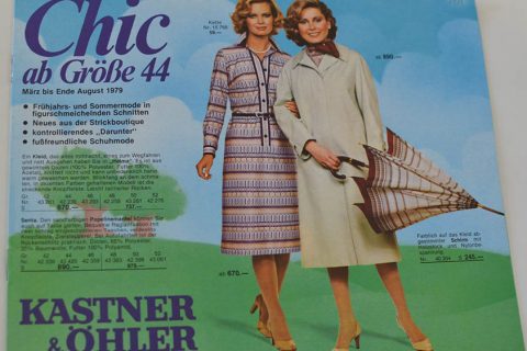 Seite eines Vintage-Modemagazins mit zwei Frauen in modischer Kleidung von März bis August 1979. Eine trägt ein gemustertes Kleid und eine Jacke, die andere einen Mantel mit einem Regenschirm mit Streifenmuster. Der Text enthält Preise und den Ladennamen „Kastner & Öhler“.