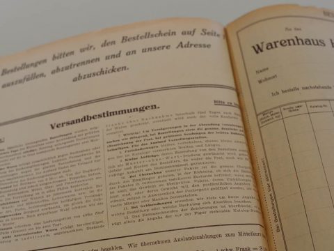 Ein offener Vintage-Katalog mit Text in deutscher Sprache, einschließlich Überschriften und Abschnitten für Bestellanweisungen und Versandbedingungen. Die Seiten sind vergilbt, was auf das Alter hinweist.