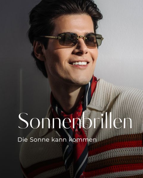 Ein Mann mit Sonnenbrille und gestreiftem Pullover lächelt im Sonnenlicht. Der Text lautet: "Sonnenbrillen. Die Sonne kann kommen.