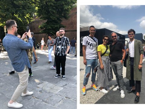 Menschen stehen im Freien; links fotografiert ein Mann einen anderen Mann in gemusterter Kleidung. Rechts posieren vier Menschen zusammen, die in lässigen, modischen Outfits gekleidet sind. Im Hintergrund sind Bäume und ein Gebäude zu sehen.