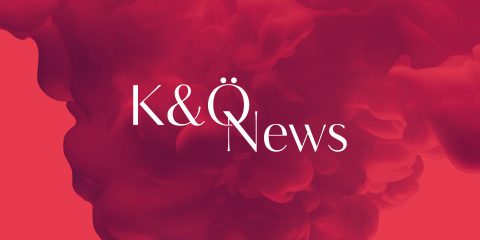Roter rauchiger Hintergrund mit weißem Text in der Mitte mit der Aufschrift „K&Ö News“.