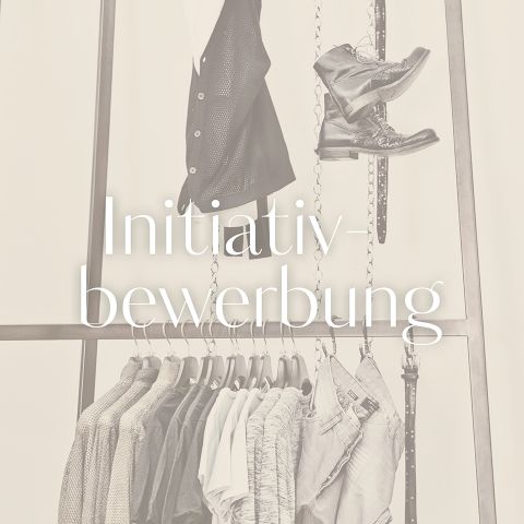 Ein Kleiderständer mit ordentlich aufgehängter Kleidung und einem Paar Stiefel darauf. Der Text „Initiativbewerbung“ ist über das Bild gelegt.