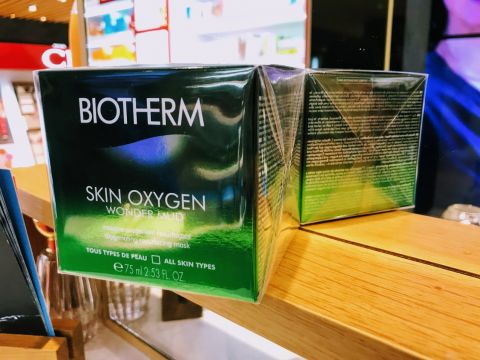 Eine Nahaufnahme von zwei Biotherm Skin Oxygen Wonder Mud-Boxen, die auf einem Regal ausgestellt sind. Die Verpackung ist grün mit weißem Text und zeigt, dass es sich bei dem Produkt um eine Sauerstoff spendende Reinigungsmaske für alle Hauttypen handelt.