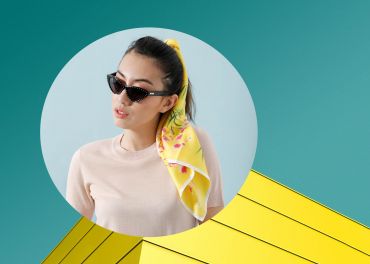 Eine Frau mit Cat-Eye-Sonnenbrille und einem gelben Schal im Haar vor einem blaugrünen Hintergrund. Sie befindet sich in einem runden Rahmen, der unten rechts ein geometrisches Design mit gelben Dreiecken überlagert.