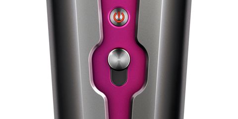 Nahaufnahme eines eleganten Geräts mit metallischen Bedienfeldern und einem leuchtend rosa Akzent. Verfügt über einen rot beleuchteten Einschaltknopf und darunter über einen runden silbernen Knopf.