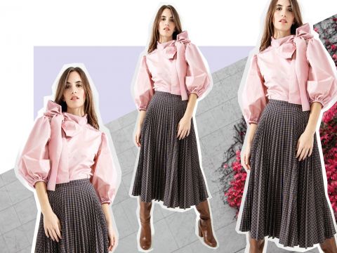 Eine Frau in einer rosa Bluse mit Puffärmeln und großer Schleife und einem karierten Faltenrock ist in drei identischen Posen vor einem Hintergrund mit grauen Kacheln und rotem Laub gestylt. Sie trägt braune kniehohe Stiefel.