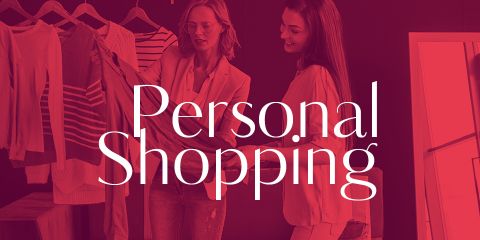 Zwei Frauen sind beim Personal Shopping dabei und begutachten Kleidung auf einem Ständer. Die Worte „Personal Shopping“ sind deutlich über dem Bild zu sehen. Die Kulisse scheint eine stilvolle, gut organisierte Boutique zu sein.