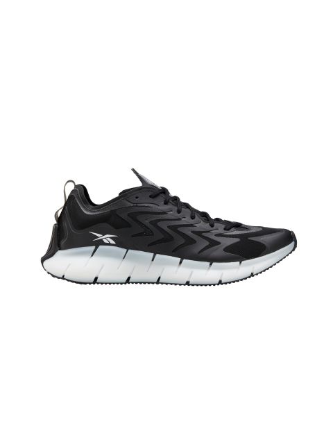 Ein schwarzer Sportschuh mit gewellter weißer Sohle und schwarzen Schnürsenkeln sowie einem weißen Logo an der Seite. Das Design weist auf der Oberseite ein schlichtes Muster auf, das ihm auf weißem Hintergrund einen modernen und sportlichen Look verleiht.
