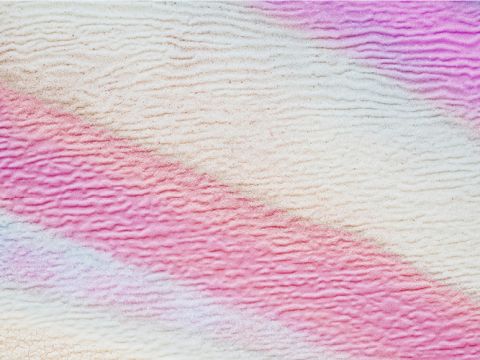 Abstraktes Bild mit weichen, gewellten Linien in Rosa-, Lila- und Weißtönen. Die Textur ähnelt einer gewellten Oberfläche und erzeugt ein beruhigendes, geschichtetes Muster.