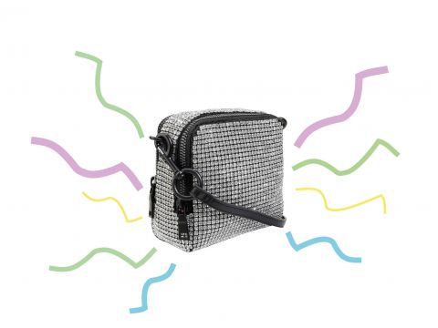 Eine kleine, rechteckige, silbern glitzernde Umhängetasche mit schwarzem Riemen ist nach rechts geneigt. Bunte Wellenlinien in Lila, Gelb, Grün und Blau umgeben die Tasche auf weißem Hintergrund.