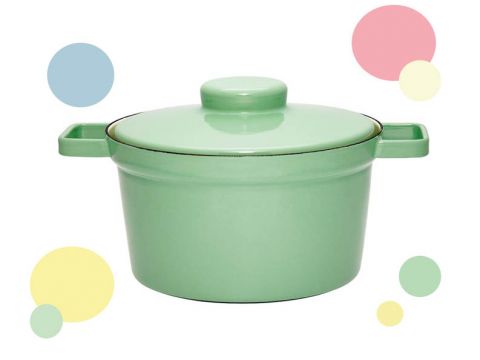 Ein grüner Kochtopf mit Deckel und seitlichen Griffen vor einem weißen Hintergrund mit bunten Kreisen in Pastellblau, Rosa, Gelb und Grün.