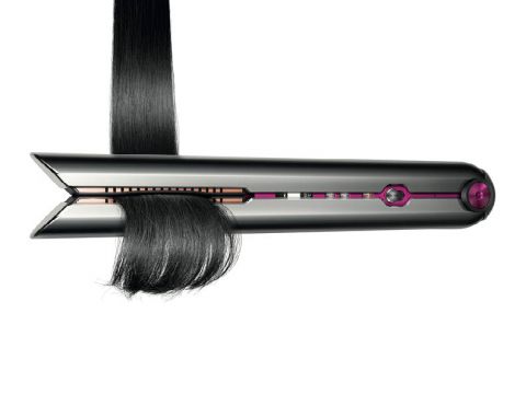 Ein Hightech-Haarglätter mit elegantem Design glättet eine schwarze Haarpartie. Das Gerät hat eine metallische Oberfläche mit rosa Akzenten und ein Display an der Seite.