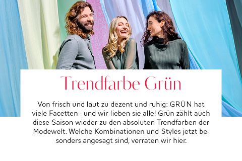 Drei Menschen lächeln und unterhalten sich vor bunten Stoffhintergründen. Der Text befasst sich mit Grün als Trendfarbe und hebt ihre Vielseitigkeit und Beliebtheit in dieser Saison hervor.