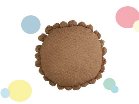 Rundes, braunes Kissen mit strukturiertem Stoff und Pomponbesatz an den Rändern. Auf einem weißen Hintergrund mit verstreuten bunten pastellfarbenen Kreisen.