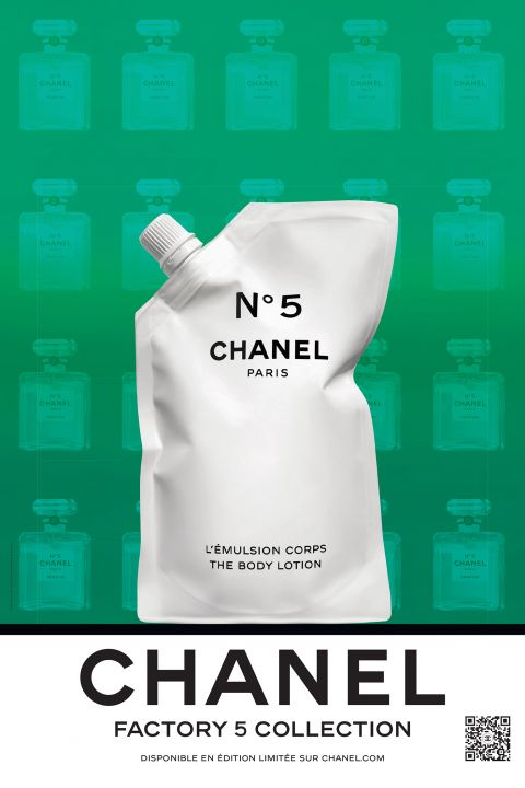 Ein weißer Beutel mit Ausgießer für die Körperlotion Chanel No. 5 steht vor einem grünen Hintergrund mit schwachen Bildern von Chanel-Parfümflaschen. Der Text lautet „Factory 5 Collection“ und enthält unten einen QR-Code.