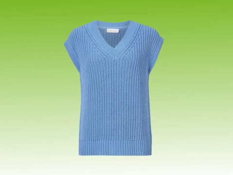 Ein blauer ärmelloser Strickpullover mit V-Ausschnitt vor einem grünen Hintergrund mit Farbverlauf.