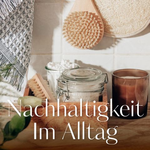 Eine gemütliche Badezimmerszene mit Holzbürsten, Wattestäbchen, einem Glasgefäß und einer braunen Kerze auf einem Regal. Im Hintergrund hängt ein Handtuch. Der Text im Bild lautet „Nachhaltigkeit im Alltag“.