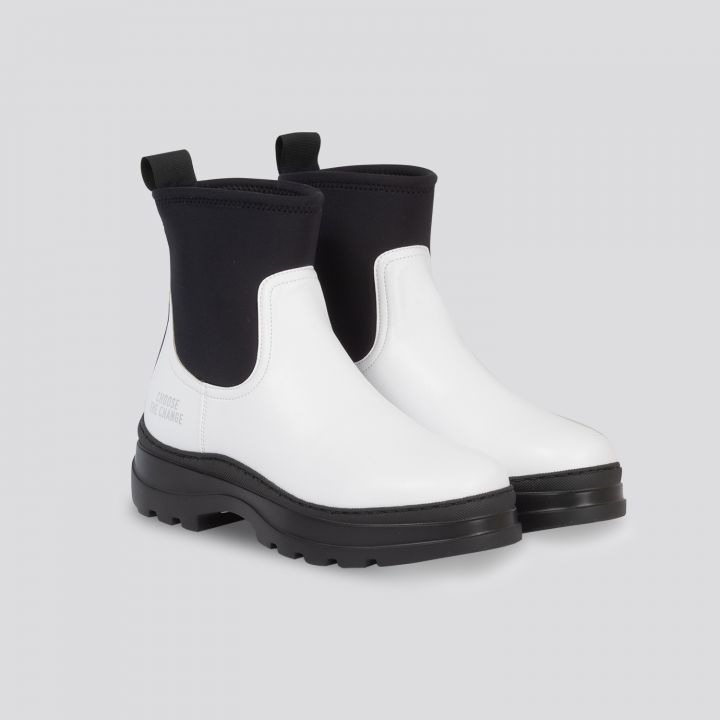 Ein Paar weiß-schwarze Stiefeletten mit dicken Sohlen. Die Stiefel haben hinten Laschen und weisen auf einem schlichten Hintergrund ein elegantes, modernes Design auf.