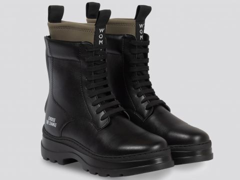 Ein Paar schwarze Schnürstiefeletten mit dicker Sohle und Laschen. Auf der Rückseite der Ferse steht „CHOOSE FRANCE“. Die Stiefel haben ein elegantes Design mit WOM-Label auf den Laschen vor einem neutralen Hintergrund.