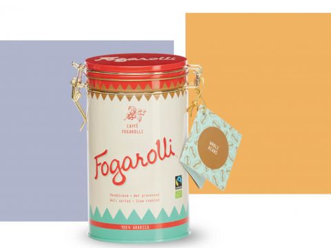 Eine Dose Fogarolli-Kaffee mit rotem Deckel, einem Vintage-Design und einem Etikett an der Seite. Der Hintergrund besteht aus einem blauen und orangefarbenen Farbblock.