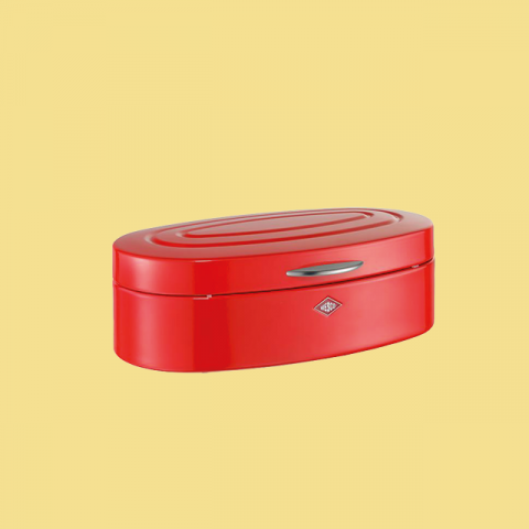 Eine rote, ovale Brotbox mit schlankem, modernem Design und silbernem Griff steht auf einem gelben Hintergrund.