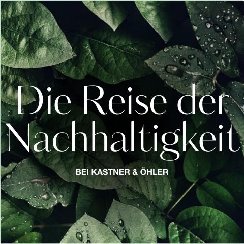 Nahaufnahme von grünen Blättern mit Wassertropfen. Der Text „Die Reise der Nachhaltigkeit bei Kastner & Öhler“ ist weiß darübergelegt und weist auf einen Fokus auf Nachhaltigkeit hin.