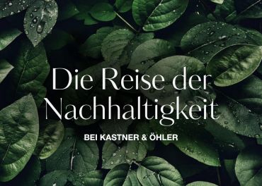 Auf grünen Blättern mit Wassertropfen überlagerter Text lautet: „Die Reise der Nachhaltigkeit bei Kastner & Öhler.“.