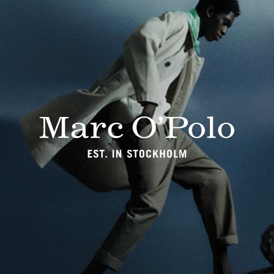 Ein Model posiert dynamisch vor einem dunklen Hintergrund. Es trägt einen hellen Trenchcoat, ein weißes Hemd und eine dunkle Hose. Der Text „Marc O'Polo EST. in Stockholm“ ist auf dem Bild deutlich zu sehen.