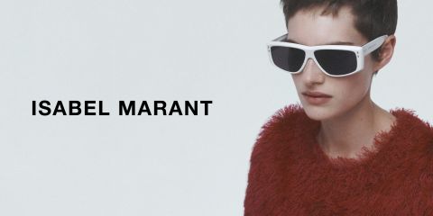 Eine Person mit kurzen Haaren trägt eine weiße Sonnenbrille und ein strukturiertes rotes Oberteil. Der Hintergrund ist schlicht, mit dem Text „ISABEL MARANT“ auf der linken Seite. Der Stil ist modern und schick.