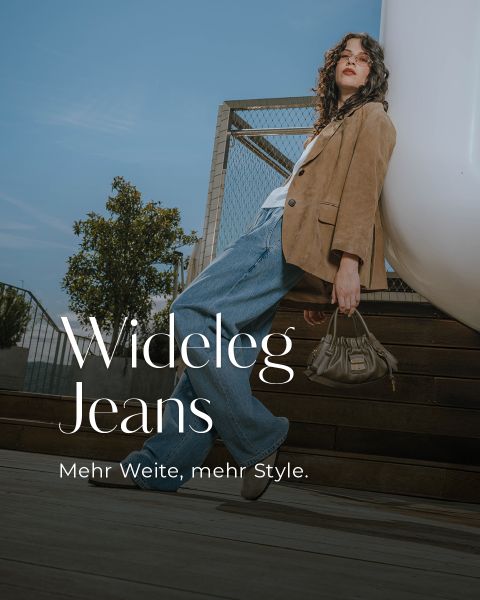 Eine Frau in weit geschnittenen Jeans, einem braunen Blazer und einer Sonnenbrille posiert im Freien auf einer Holztreppe und hält eine Handtasche. Der Text lautet: "Wideleg Jeans. Mehr Weite, mehr Style." Blauer Himmel und Pflanzen im Hintergrund.