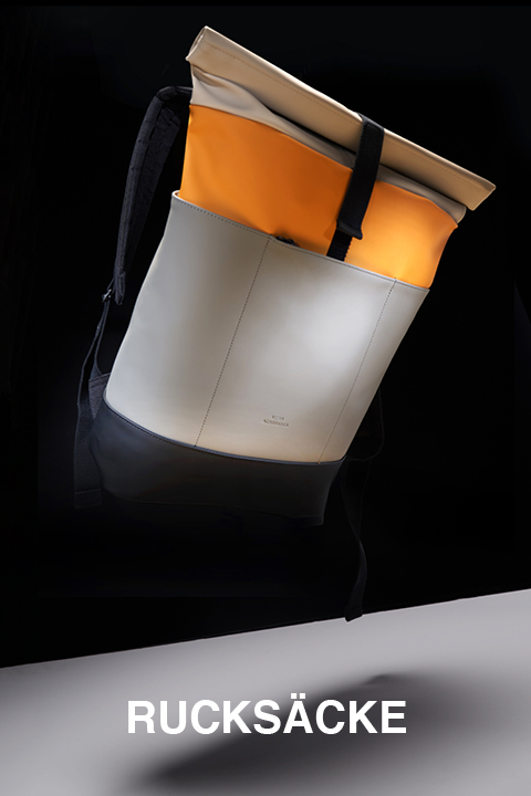 Ein stylischer, moderner Rucksack mit kontrastierenden beigen, orangen und schwarzen Elementen sticht vor einem dunklen Hintergrund hervor. Unter der Tasche steht in fetten weißen Buchstaben das Wort „Rucksäcke“.