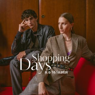 Zwei modisch gekleidete Personen sitzen auf roten Möbeln vor einer Holzvertäfelung. Der Text lautet: „Shopping-Tage 9. und 10.10.2026.“.