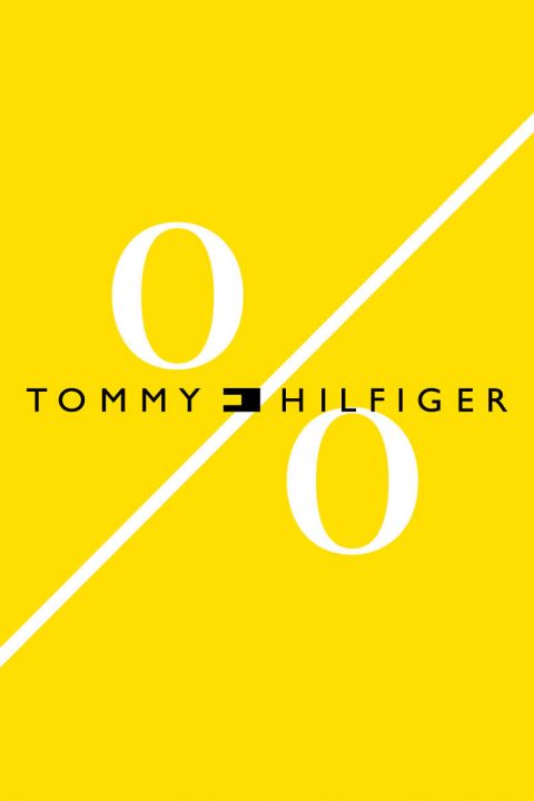 Ein gelber Hintergrund mit einem großen weißen Prozentsymbol. Der Markenname „Tommy Hilfiger“ ist in Schwarz gehalten und schneidet das Symbol horizontal.