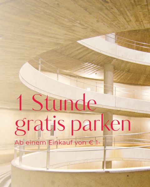 Spiralförmige Rampen in einem Parkhaus aus Beton mit dem Werbetext „1 Stunde gratis parken ab einem Einkauf von €1,-“ im Vordergrund, was übersetzt „1 Stunde gratis Parken ab einem Einkauf von €1,-“ bedeutet.