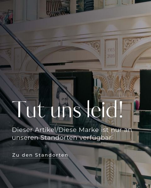 Ein elegantes Ladeninterieur mit aufwendigen Wanddesigns und Kunstwerken. Eine Treppe mit Glasgeländer führt hinunter. Die Texteinblendung lautet: „Tut uns leid! Dieser Artikel/Diese Marke ist nur an unseren Standorten verfügbar.“.
