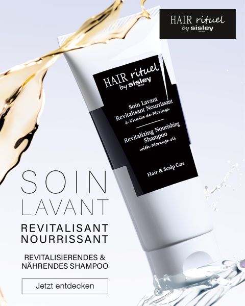 Abgebildet ist eine Tube „Hair Rituel by Sisley“ Revitalisierendes Pflegeshampoo mit Moringaöl. Im Hintergrund ist ein Wasserspritzer zu sehen. Der Text lautet „Soin Lavant Revitalisant Nourrissant“ und „Jetzt entdecken.