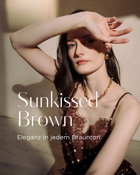 Eine Frau in einem braunen Spitzenkleid posiert im Sonnenlicht und hält sich die Augen zu. Der Text lautet: "Sunkissed Brown: Eleganz in jedem Braunton.