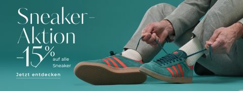 Person bindet die Schnürsenkel blaugrüner Sneaker mit orangefarbenen Streifen und trägt hellgraue Hosen und weiße Socken. Der Text lautet „Sneaker Aktion -15 % auf alle Sneaker. Jetzt entdecken“ auf blaugrünem Hintergrund.