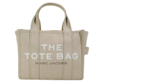 Beigefarbene Tragetasche mit Griffen und den Worten „THE TOTE BAG“ und „MARC JACOBS“ in Weiß auf der Vorderseite aufgedruckt. Die Tasche ist schlicht und strukturiert, mit sichtbaren Nähten und einem seitlichen Riemendetail.